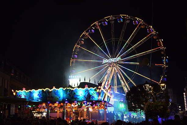 Lit up Ferris wheel with bright light in the middle on a dark December evening at Christmas market in Dortmund, Germany