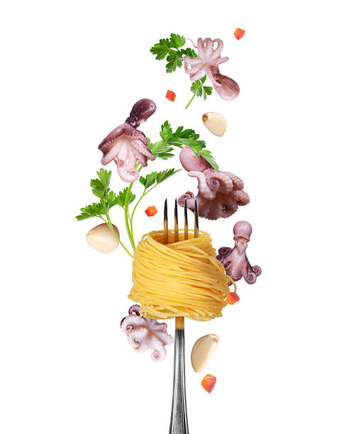 Spaghetti wrapped around fork with flying small octopuses, parsley leaves and garlic close-up isolated on a white background