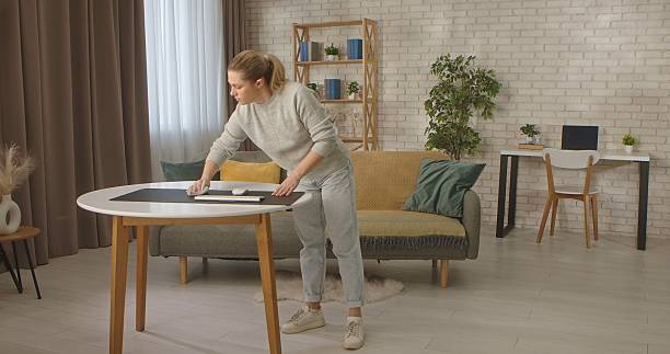 istock Woman Cleaning Table in Cozy Home Interior 2254163592