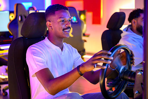 istock Young adult enjoying virtual reality racing with steering wheel setup 2254169730