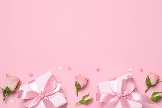 istock Beautiful pink roses with gift boxes on color background 2254173888
