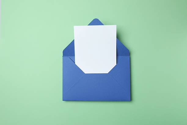 istock Paper envelope with white card on green background 2254174285