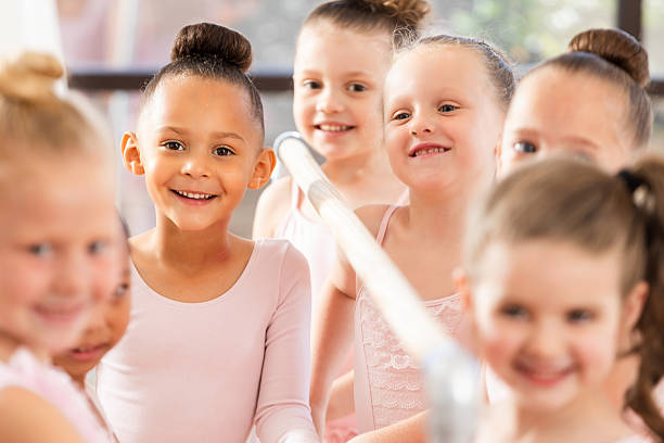 istock Young dancers in a ballet class smiling joyfully around a barre during lesson. 2254174351