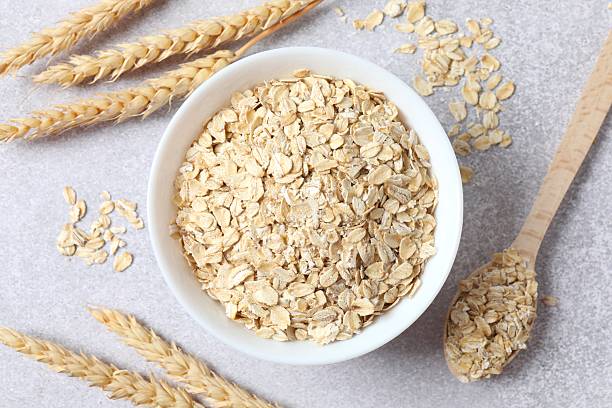 istock Composition with oatmeal flakes on gray background. Cooking breakfast 2254174426