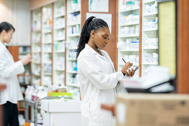 istock African American Woman Pharmacist in White Coat Writing Notes in Modern Pharmacy Setting 2254176100