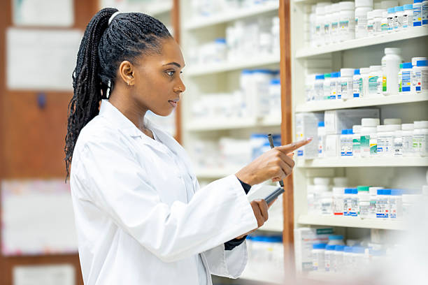 istock Pharmacist In White Lab Coat Organizing Medicine Bottles On Pharmacy Shelves 2254176540