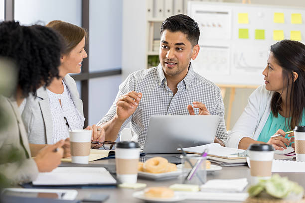 istock Diverse professionals collaborate and brainstorm ideas during a business meeting around a table with a laptop. 2254177528