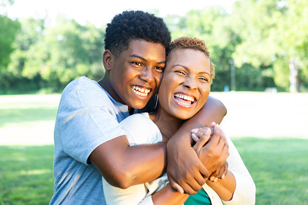 istock Mother and son share a joyful hug outdoors on a sunny day, surrounded by nature. 2254181674