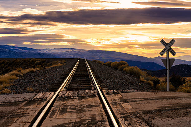 Scenic view with train tracks leading off into the distance with high mountains in background.