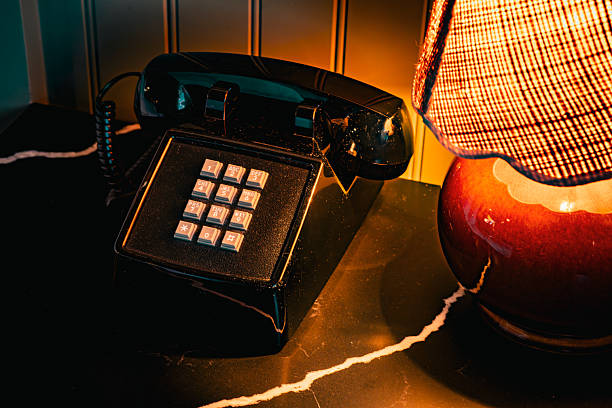 istock Vintage black rotary phone with illuminated lamp on a marble surface 2254187207