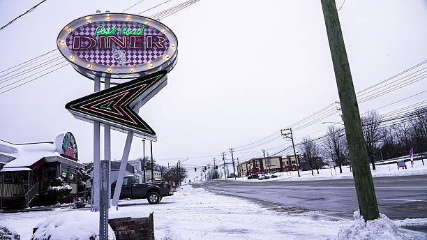 Norwalk, CT, USA- December 27, 2025: Snow falls in Norwalk, covering the Post Road Diner The scene shows winter weather's impact on the town with Post Road Diner sign near Post Road