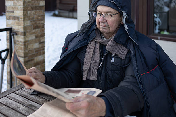 istock Senior Man Reading Newspaper Outdoors 2254195365
