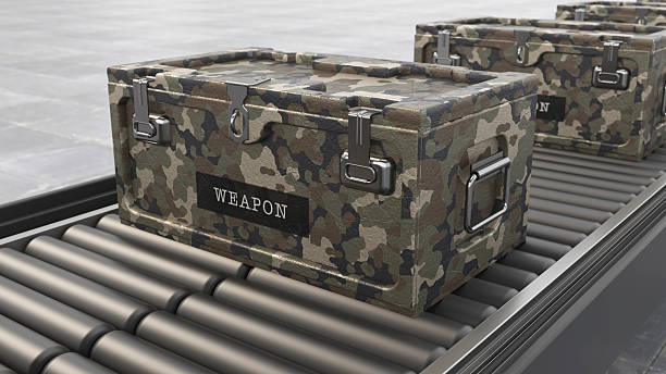 Large group of containers with weapons standing on the ground inside a distribution warehouse. The setting shows a modern facility with several similar containers in view.
