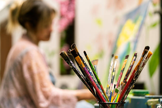 istock Artist painting canvas with paintbrushes in studio 2254197136
