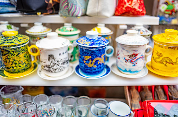 A close shot of lidded porcelain cups, vivid blue and yellow glazes with dragon motifs — crisp details that evoke traditional cultural charm.