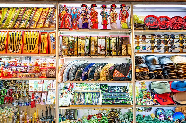 Shelves neatly display folding fans, jewelry, sunglasses and caps — a colorful array of souvenirs that conveys a bustling market vibe.