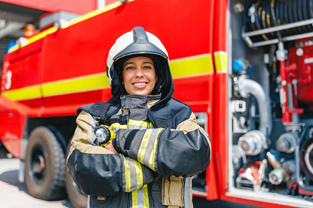 istock Joyful Young Hispanic Female Firefighter Standing Confidently Beside Red Emergency Response Vehicle 2254202499