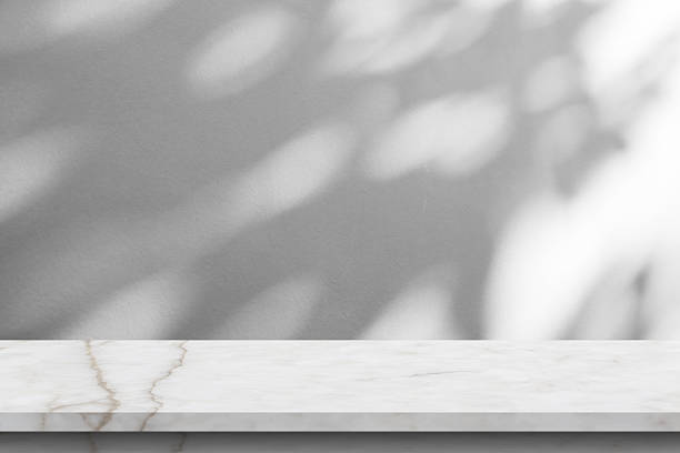 istock Marble table with tree shadow drop on white wall background for mockup product display 2254202638