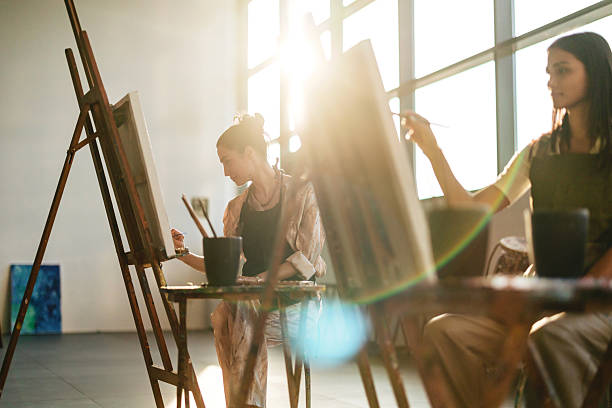 istock Young Middle Eastern Women Painting in Sunlit Art Studio 2254203351