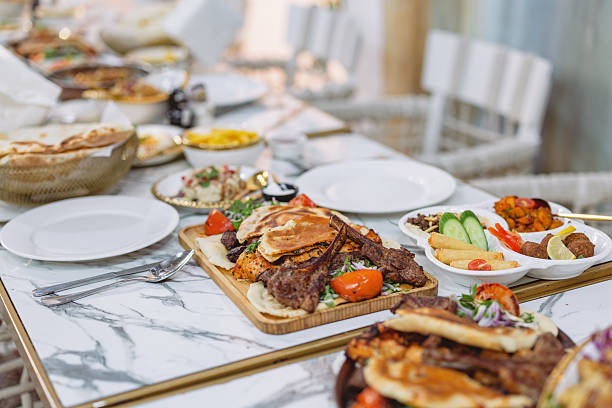 A vibrant spread of Middle Eastern cuisine featuring grilled meats, fresh vegetables, flatbreads, and colorful side dishes served on a marble table in Dubai.