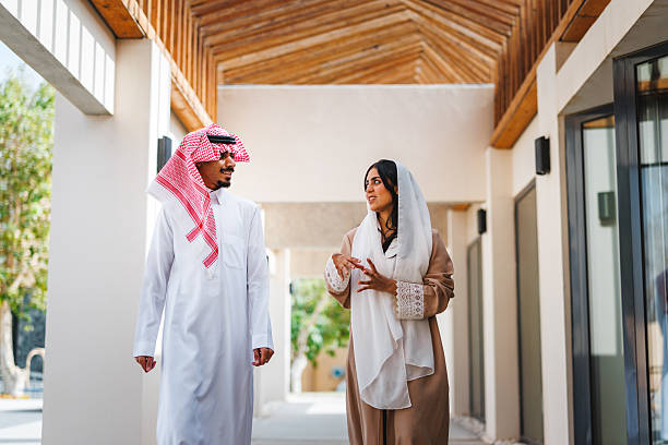 istock Middle Eastern Man and Woman Engaging in Lively Discussion in Covered Corridor 2254205016