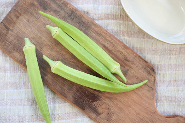 istock Fresh Okra Pods on Rustic Wooden Cutting Board 2254212278