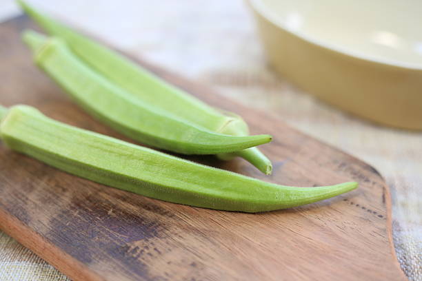 istock Fresh Okra Pods on Rustic Wooden Cutting Board 2254212280