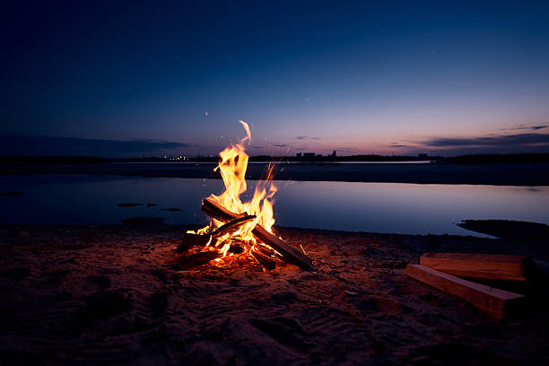 istock Burning fire on riverbank late in the evening 2254213972
