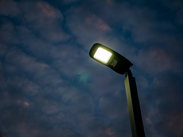 istock Dramatic Sunset Sky with Altocumulus Clouds in Purple, Orange, and Blue Colors, Featuring a Street Light and Birds 2254214932