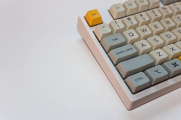 istock White mechanical keyboard with bright yellow Esc key on white background, minimalism, keyboard buttons. A keyboard with a yellow key and red volume button 2254223747