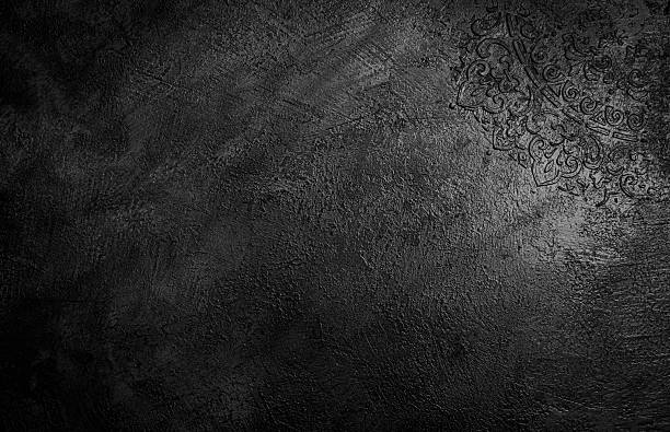 The texture of a grey black, vintage plaster wall. The dark gray background use as backdrop in design