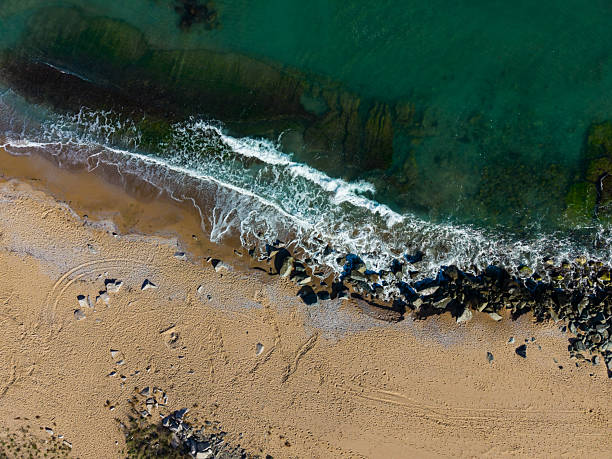 istock Waves gently lap against the sandy shore while sunlight sparkles on the clear waters of a tranquil beach at midday 2254229078