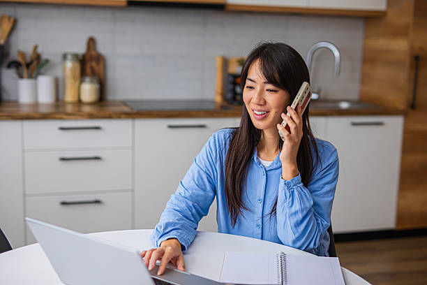 istock Smiling Woman Working from Home While Talking on Phone 2254238834