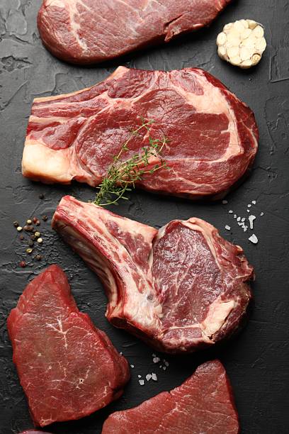 istock Pieces of raw beef meat and spices on black table, flat lay 2254243213