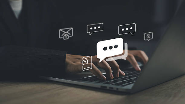 istock Secure online chat and encrypted messaging on desktop. Hands typing on laptop with floating chat bubble icons, representing safe digital communication, private conversations, and secure text exchange. 2254243720
