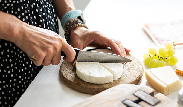 istock Girl Cutting Cheese On A Board For Cheese Board 2254244269