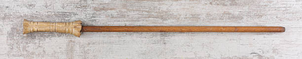 istock ancient wooden walking stick on wooden background 2254245108