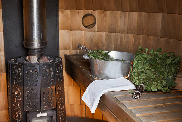 Metal stove with a chimney in a wooden sauna filled with stones. High quality photo