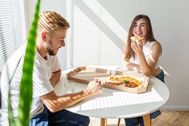 istock Happy young couple eating pizza at home 2254250721