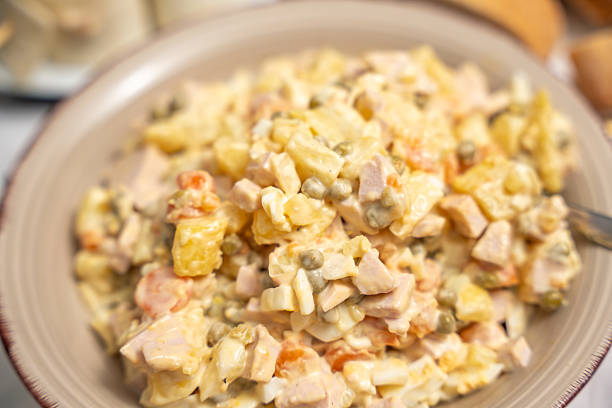 Creamy Potato Salad with Ham. Creamy homemade potato salad with ham, peas, and carrots served in a bowl. A classic comfort dish popular for family meals and gatherings.