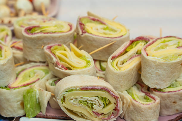 Tortilla Roll-Ups with Cheese and Ham. Tortilla roll-ups filled with cheese, ham, and lettuce, cut into bite-sized pieces. Ideal cold finger food for parties or buffets.