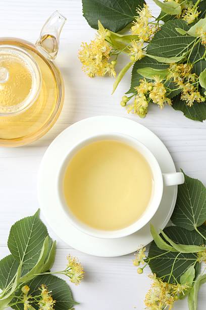 istock Green tea with fragrant linden in white cup on white background, top view 2254252953