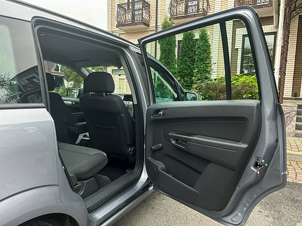 istock A spacious car interior showcases an open door, inviting passengers to explore the comfort and convenience of travel in the serene surroundings of a modern residence 2254258325