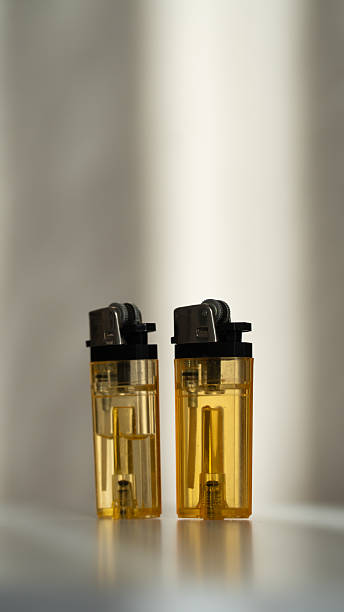 istock Two yellow transparent disposable lighters standing on a white surface. 2254269801