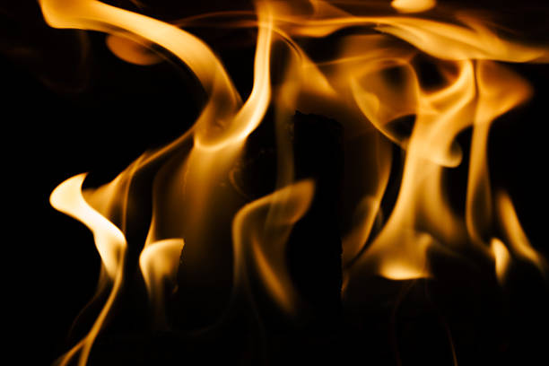 Close-up of a fire in a fireplace, against a black background
