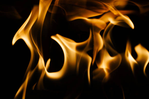 Close-up of a fire in a fireplace, against a black background