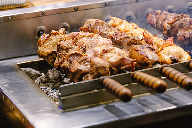 istock Succulent meat kebabs roasting on a hot grill with smoke rising from glowing coals, ready for dinner. 2254279025