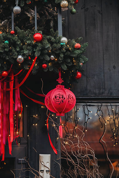 istock Vibrant red lantern hanging festive evergreen branches glowing lights silver red ornaments dark wood 2254279238