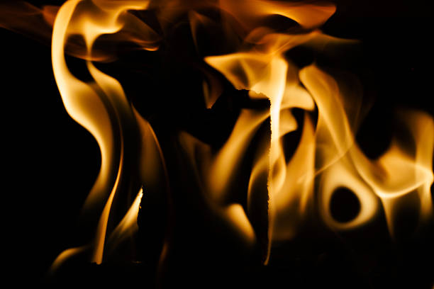 Close-up of a fire in a fireplace, against a black background