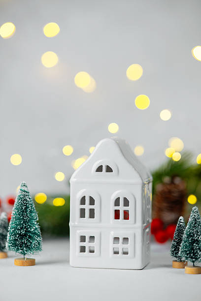 istock Ceramic house ornament with miniature trees and warm bokeh lights in soft focus 2254279720